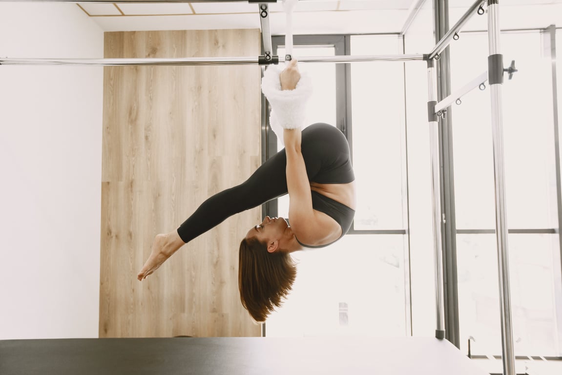 Woman Stretching on a Pilates Reformer Machine